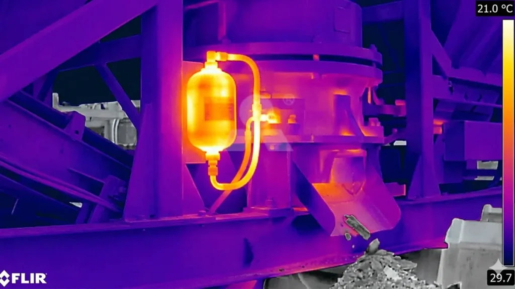 Infrared heat signature of the hydraulic accumulator reacting to a tramp iron event inside the mobile cone crusher chamber